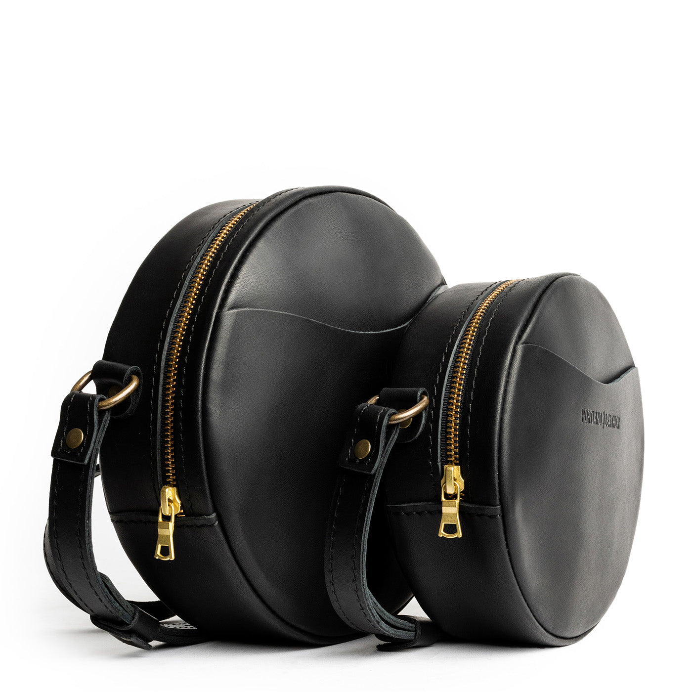 Black | Size comparison image of small and large circle shaped crossbody bags with top zipper