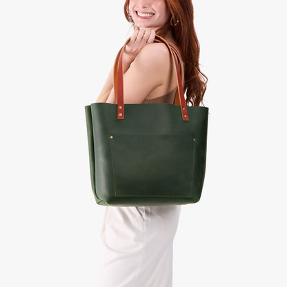 Evergreen*Classic | Model holding large leather tote bag with sturdy bridle handles and front pocket