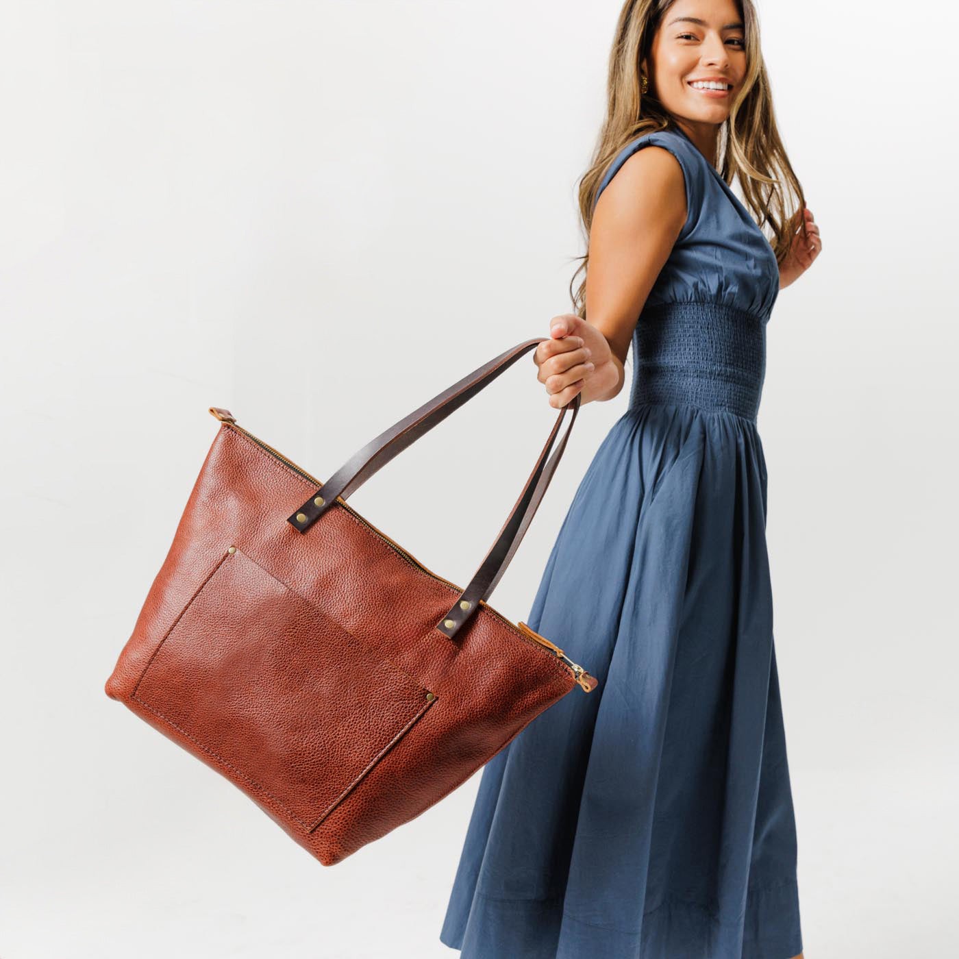 Nutmeg*Zipper | Model holding large zipper leather tote bag with sturdy bridle handles and front pocket