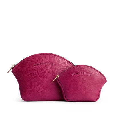 Cosmo | Comparison shot of small and large seashell shaped leather makeup bags with curved top zipper and flat bottom