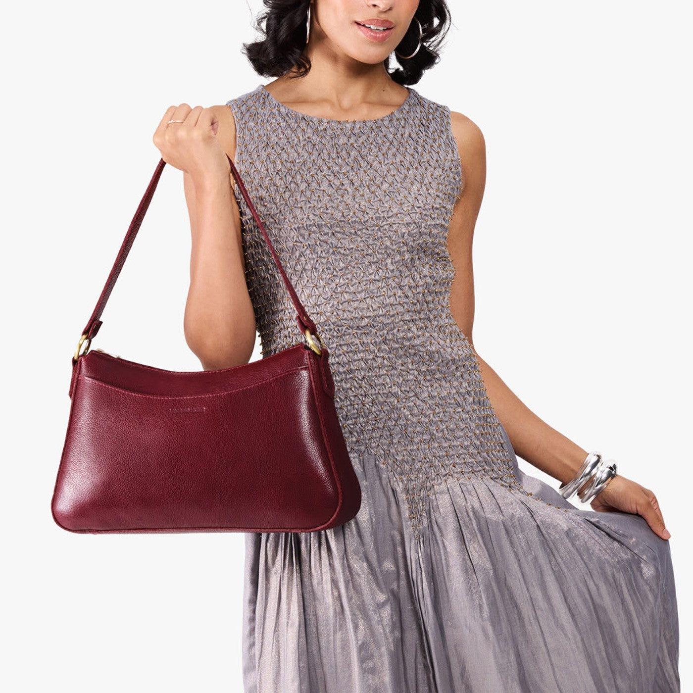 Cabernet*Large | Model holding a bean shaped shoulder bag with a zipper closure