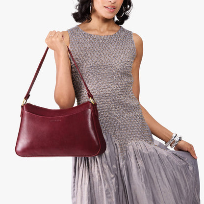 Cabernet*Large | Model holding a bean shaped shoulder bag with a zipper closure