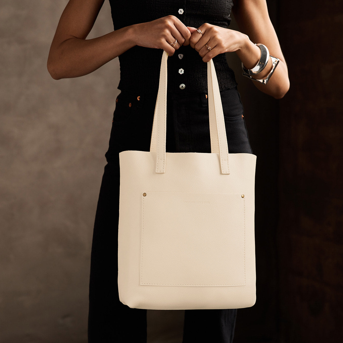 Pebbled Bone*Classic | Model holding medium Tote with dual shoulder straps and crossbody strap