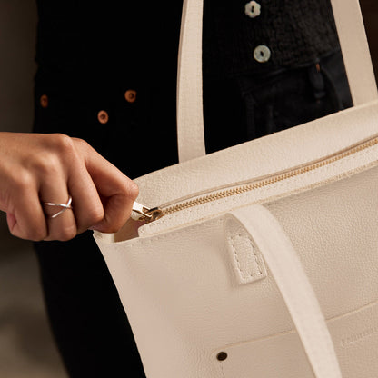 Pebbled Bone*Zipper | Model holding medium Tote with dual shoulder straps and crossbody strap