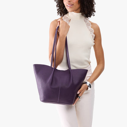 Empire*Large | Model wearing white sleeveless shirt and matching pants holding wide bucket shaped tote bag with matching leather handles