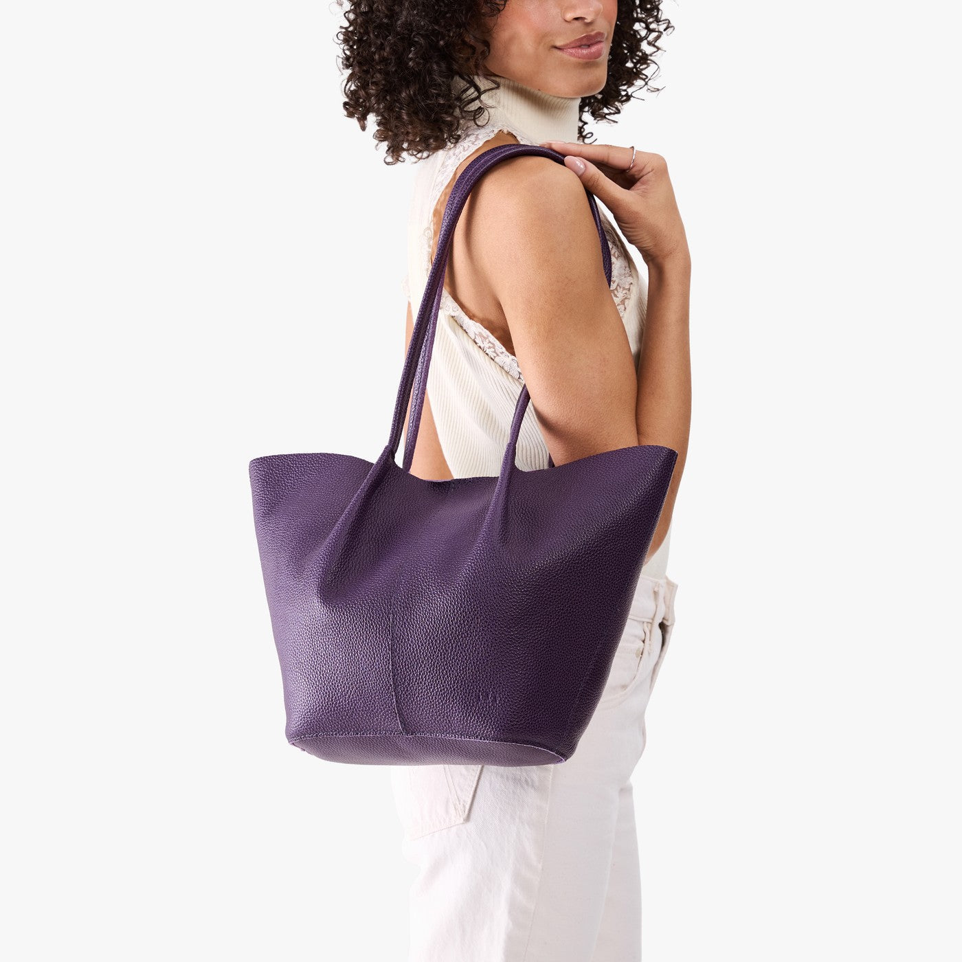 Empire*Large | Model wearing white sleeveless shirt and matching pants carrying wide bucket shaped tote bag with matching leather handles