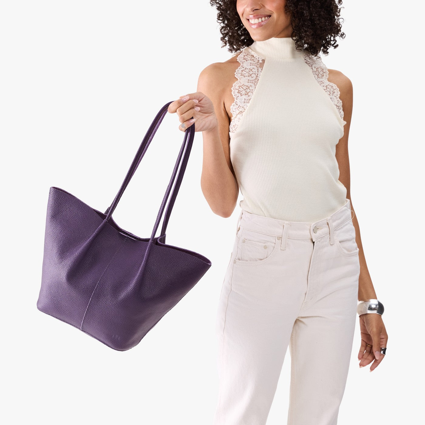 Empire*Large | Model wearing white sleeveless shirt and matching pants holding wide bucket shaped tote bag with matching leather handles