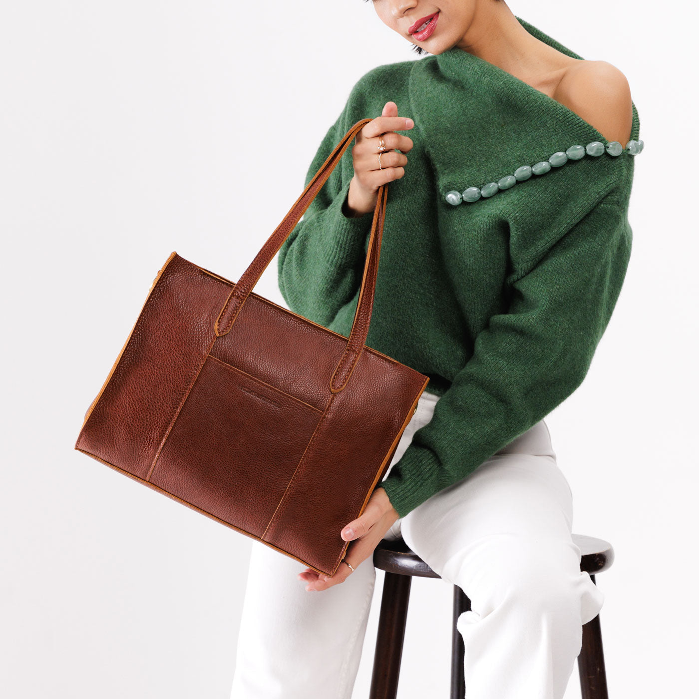 Nutmeg*East/West | Model wearing structured wide tote bag with overlapping panels and crossbody strap