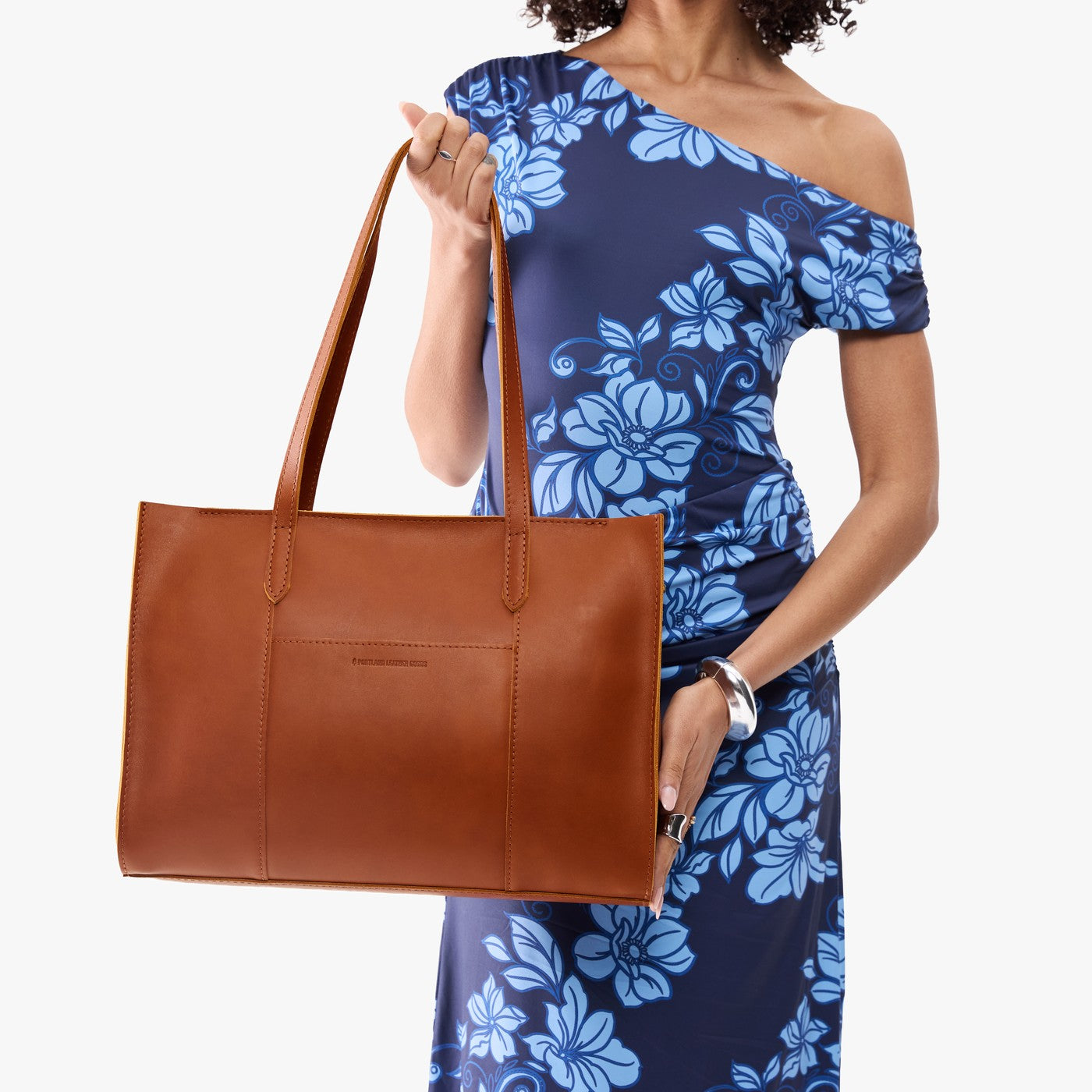 Honey*Oversized East/West | Model holding structured wide tote bag with overlapping panels and crossbody strap