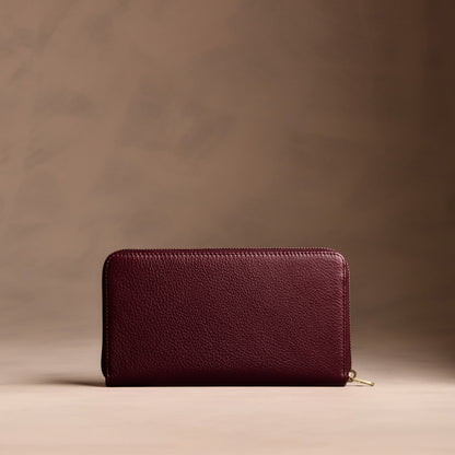 Hunter | Full zip around wallet with a strap on a brown background