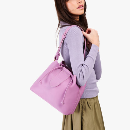 Calla Lily*Large | Model holding symmetrical leather bag with leather drawstring closure and adjustable shoulder strap