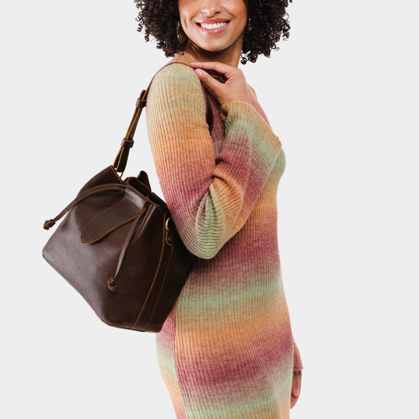Coldbrew*Large | Model holding symmetrical leather bag with leather drawstring closure and adjustable shoulder strap