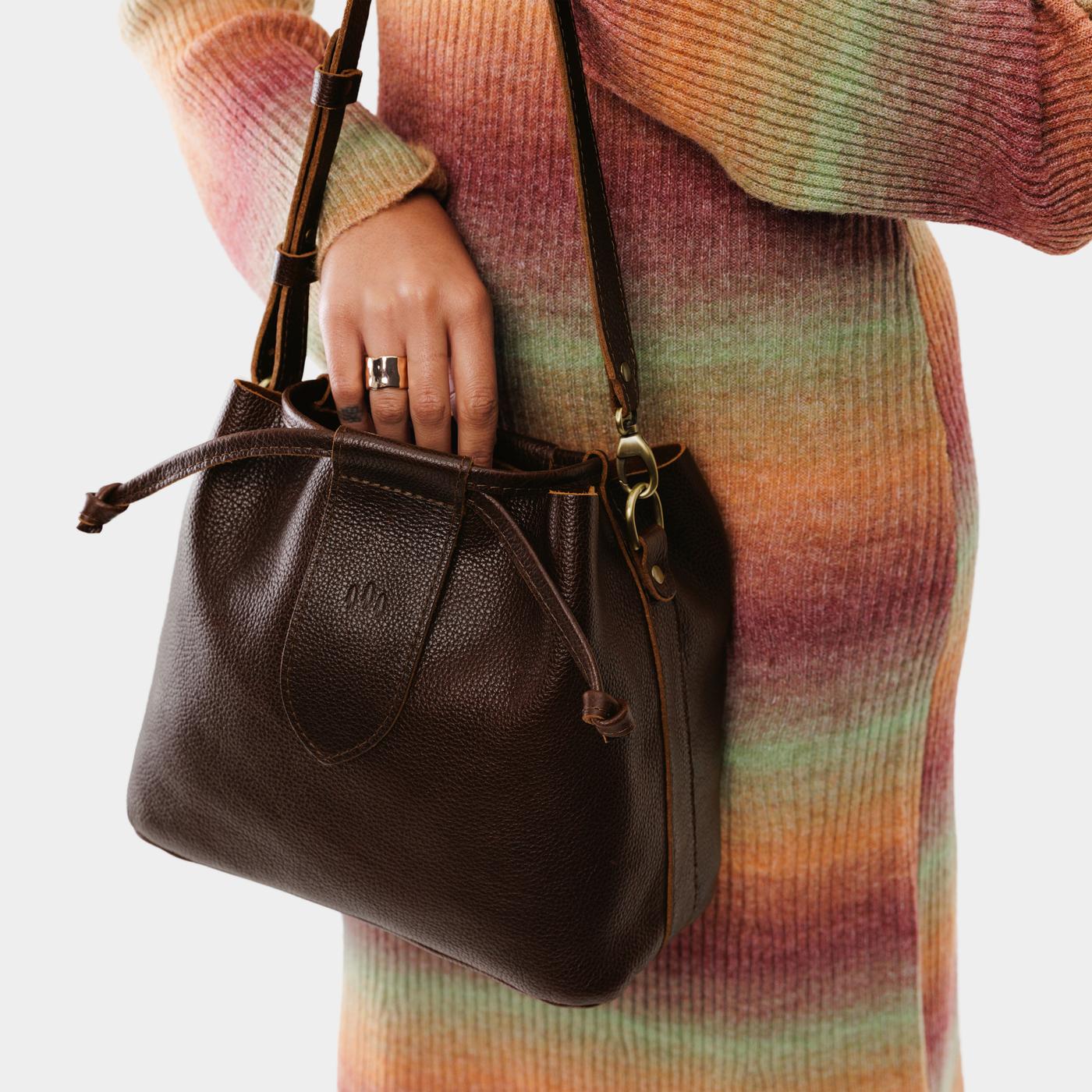 Coldbrew*Large | Model holding symmetrical leather bag with leather drawstring closure and adjustable shoulder strap