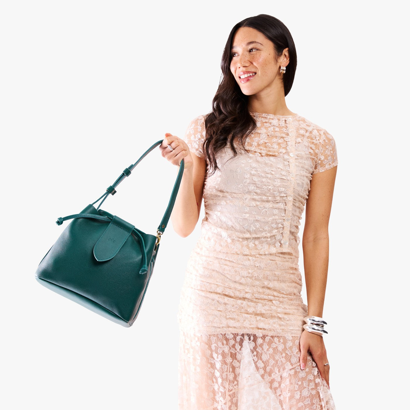 Sea Glass*Large | Model holding symmetrical leather bag with leather drawstring closure and adjustable shoulder strap