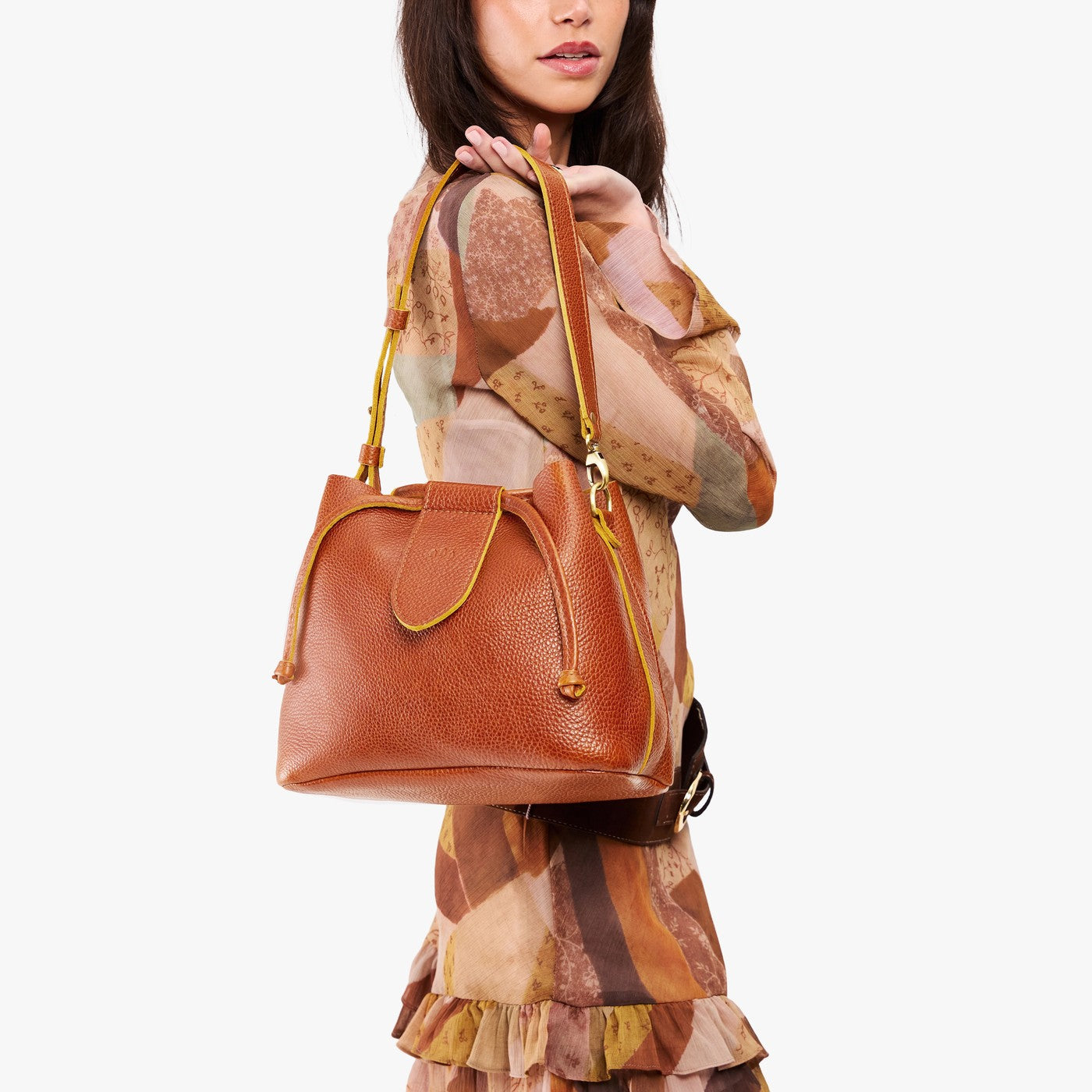 Sienna*Large | Model holding symmetrical leather bag with leather drawstring closure and adjustable shoulder strap