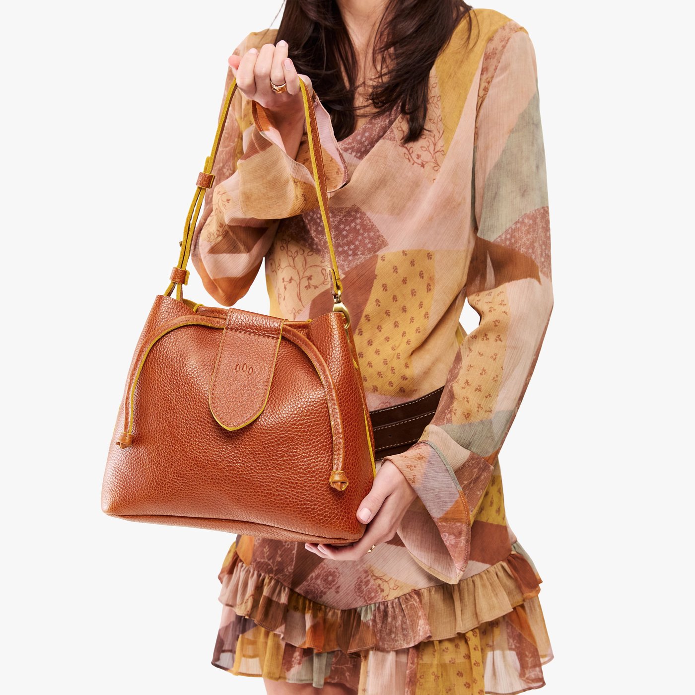 Sienna*Large | Model holding symmetrical leather bag with leather drawstring closure and adjustable shoulder strap