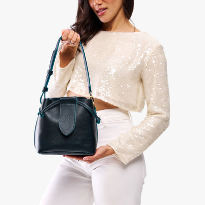 Boreal*Small | Model holding symmetrical leather bag with leather drawstring closure and adjustable shoulder strap