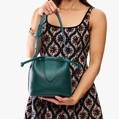 Sea Glass*Small | Model holding symmetrical leather bag with leather drawstring closure and adjustable shoulder strap