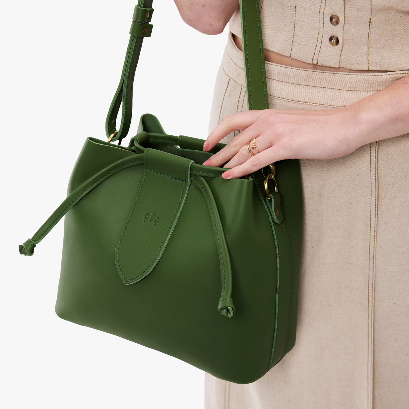 Cactus*Large | Model holding symmetrical leather bag with leather drawstring closure and adjustable shoulder strap