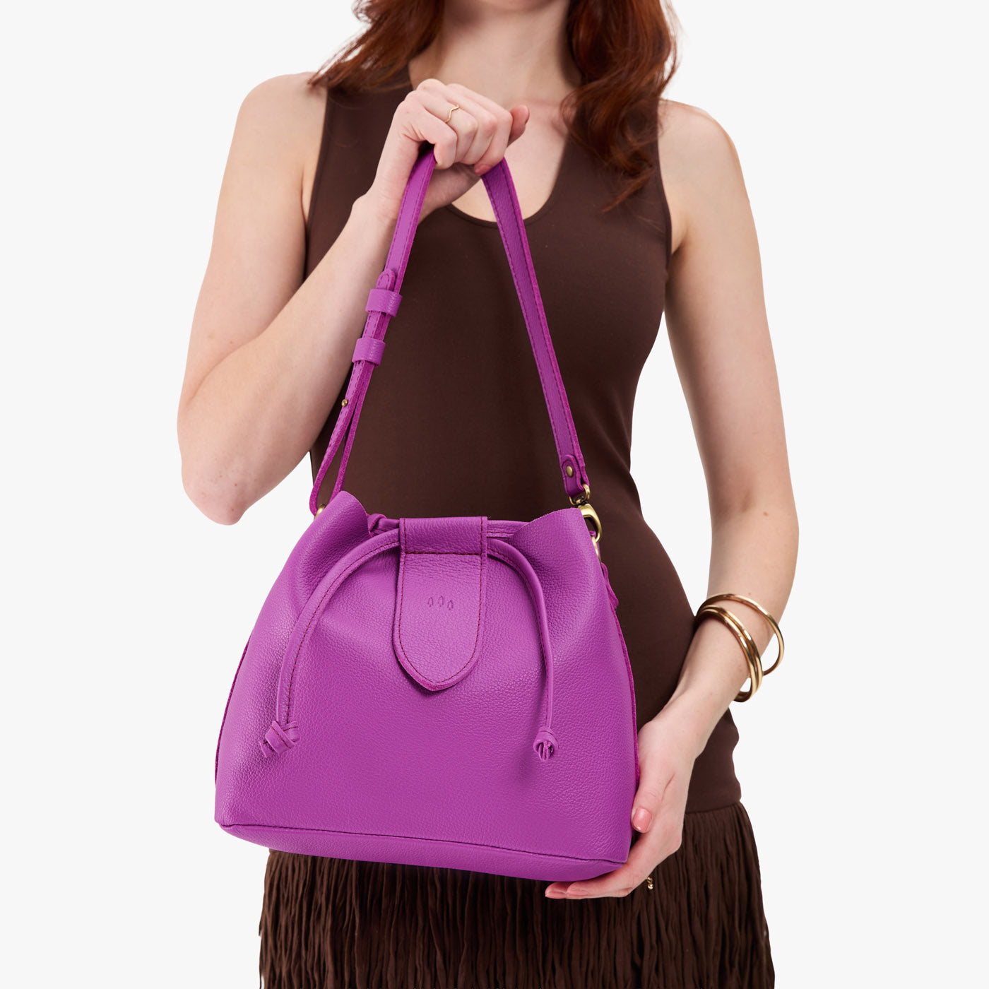 Cattleya*Large | Model holding symmetrical leather bag with leather drawstring closure and adjustable shoulder strap