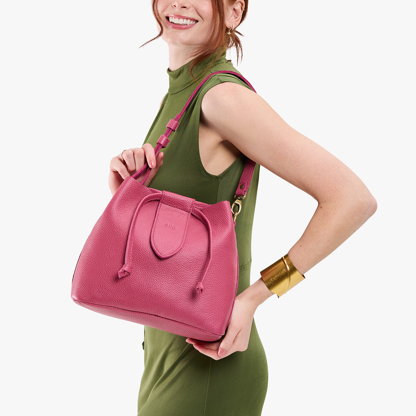 Wild Rose*Large | Model holding symmetrical leather bag with leather drawstring closure and adjustable shoulder strap