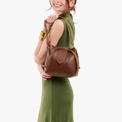 Asheville*Small | Model holding symmetrical leather bag with leather drawstring closure and adjustable shoulder strap