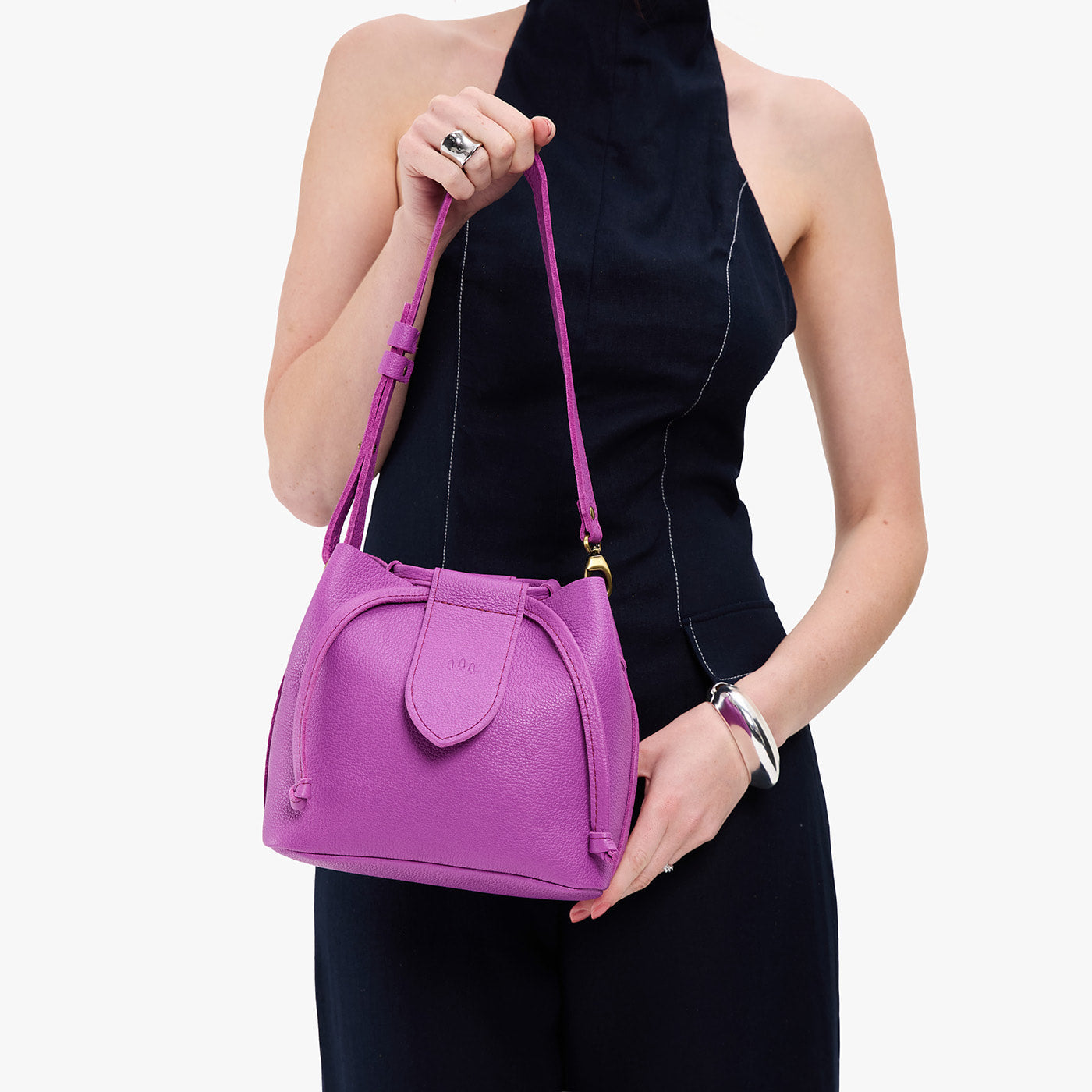 Cattleya*Small | Model holding symmetrical leather bag with leather drawstring closure and adjustable shoulder strap