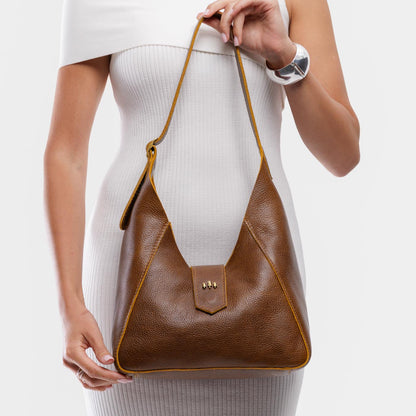 Asheville | Model holding structured hobo shoulder bag with adjustable strap and magnetic closure