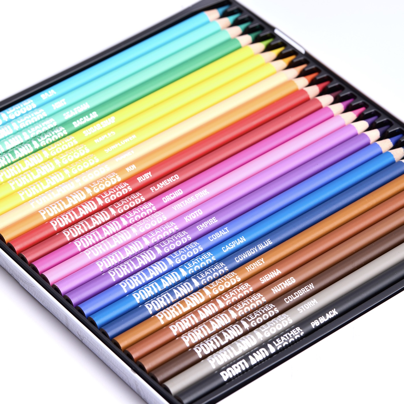 Set of colorful Portland Leather Goods branded colored pencils in a metal case.