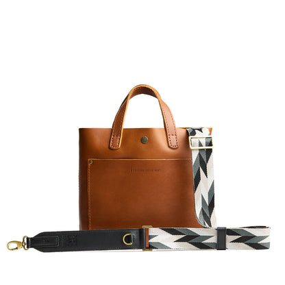Moonstone | Patterned fabric and leather strap attached to leather purse on a white background