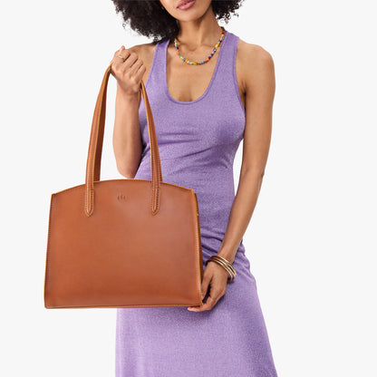 Honey*Large | Model carrying leather tote bag with handles, adjustable crossbody strap, and two back pockets