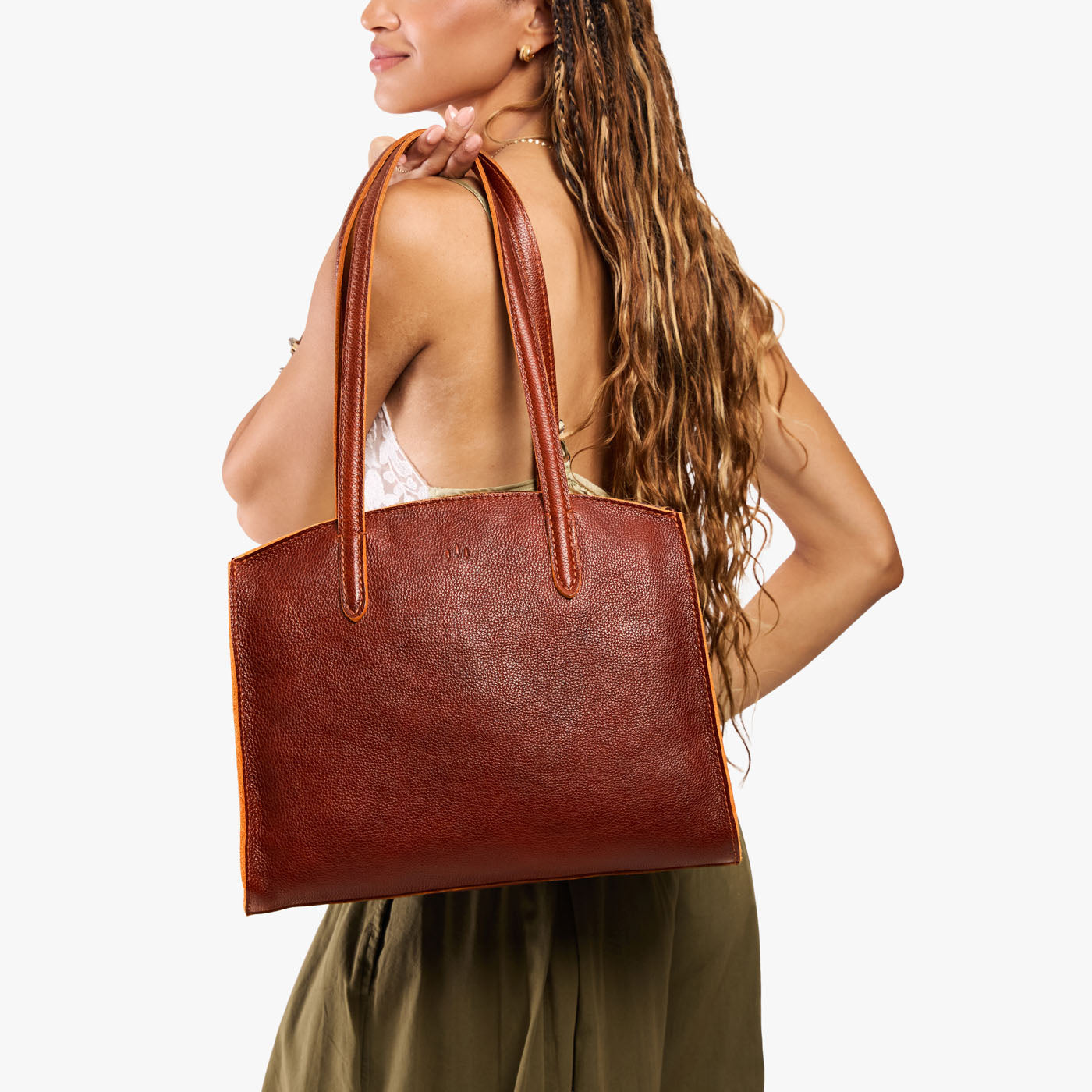 Nutmeg*Large | Model carrying leather tote bag with handles, adjustable crossbody strap, and two back pockets