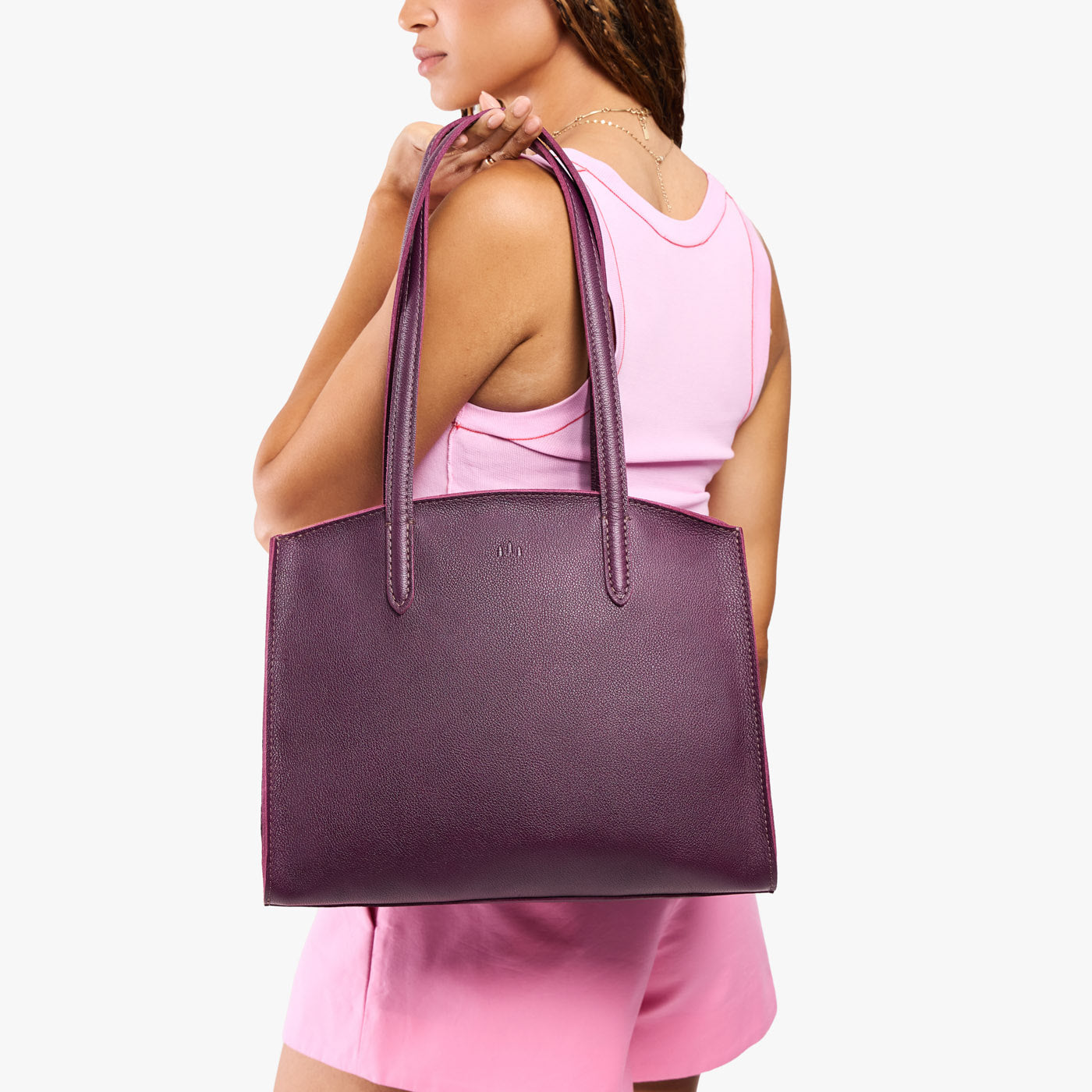 Plum*Large | Model carrying leather tote bag with handles, adjustable crossbody strap, and two back pockets