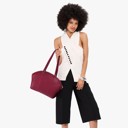 Orchid*Large | Model holding a half circle crossbody bag with handles and removable crossbody strap