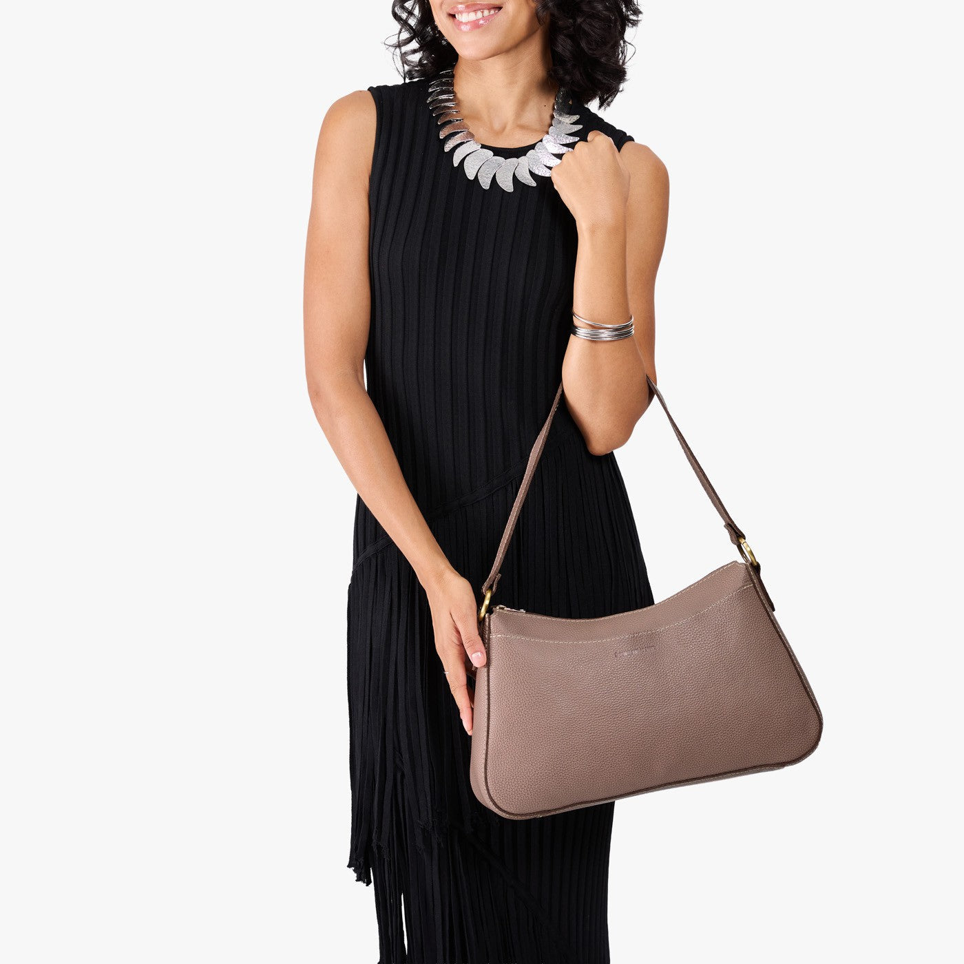 Sparrow*Large | Model holding a bean shaped shoulder bag with a zipper closure