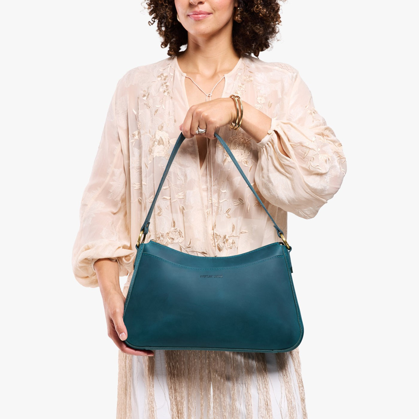Westward Blue*Large | Model holding a bean shaped shoulder bag with a zipper closure