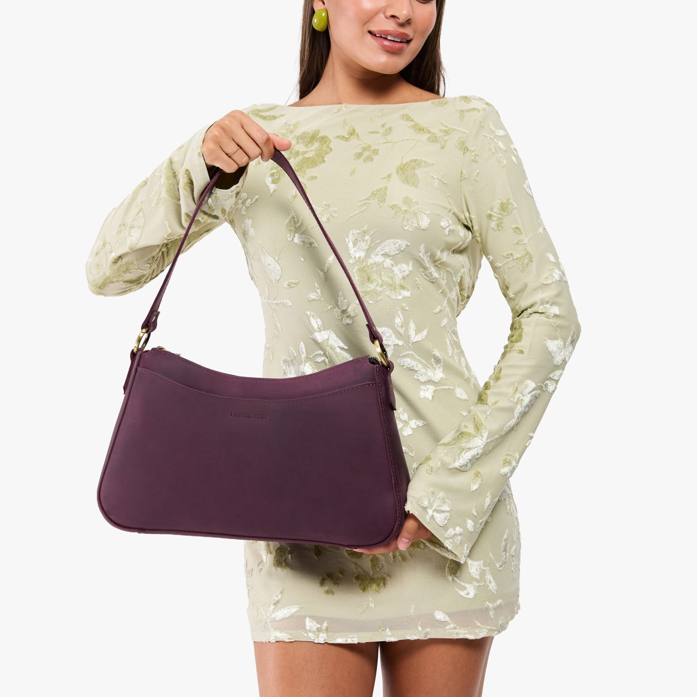 Larkspur*Large | Model holding a bean shaped shoulder bag with a zipper closure