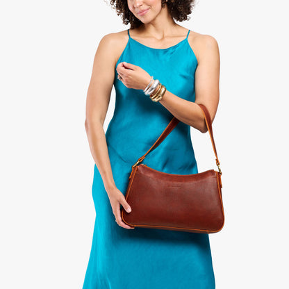 Nutmeg*Large | Model holding a bean shaped shoulder bag with a zipper closure