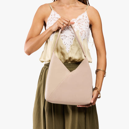 Toasted Oat*Large | Model holding mid-size shoulder bag with magnetic snap closure