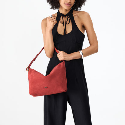 Cinnabar*Large | Model holding a Slouchy Shoulder Bag that has a zipper opening and three metal tree emblems