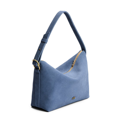 Denim*Large | Slouchy Shoulder Bag that has a zipper opening and three metal tree emblems on a white background