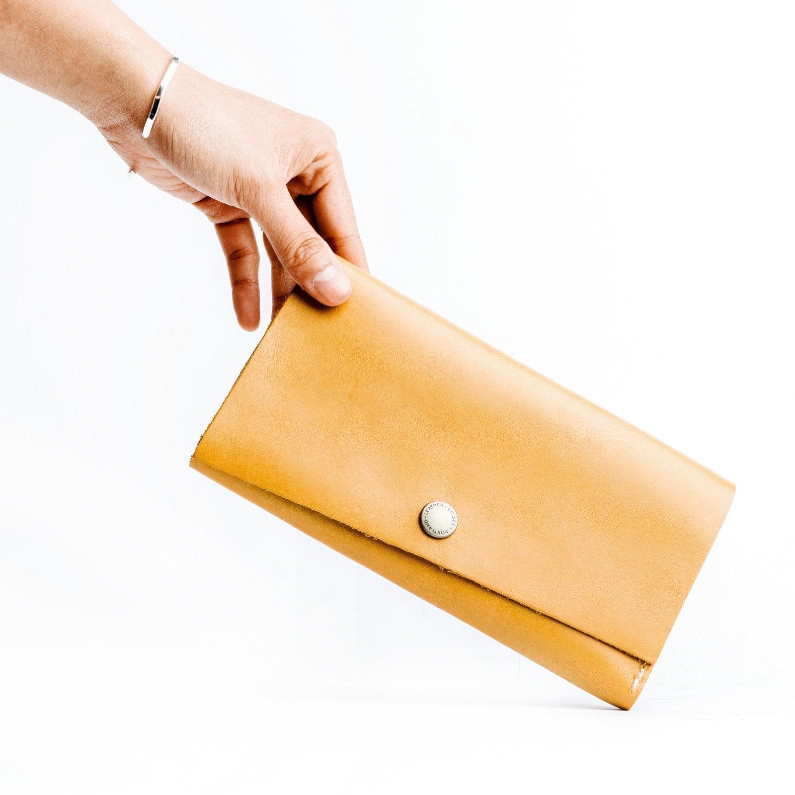 Sunflower | Model holding leather wallet with snap closure