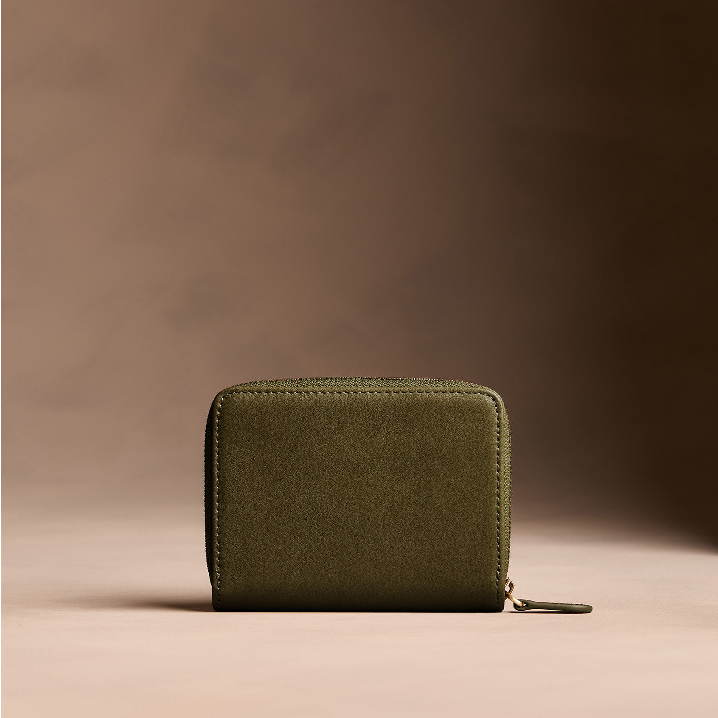 Bay Green | Wallet with card and storage pockets on a light brown background - back view