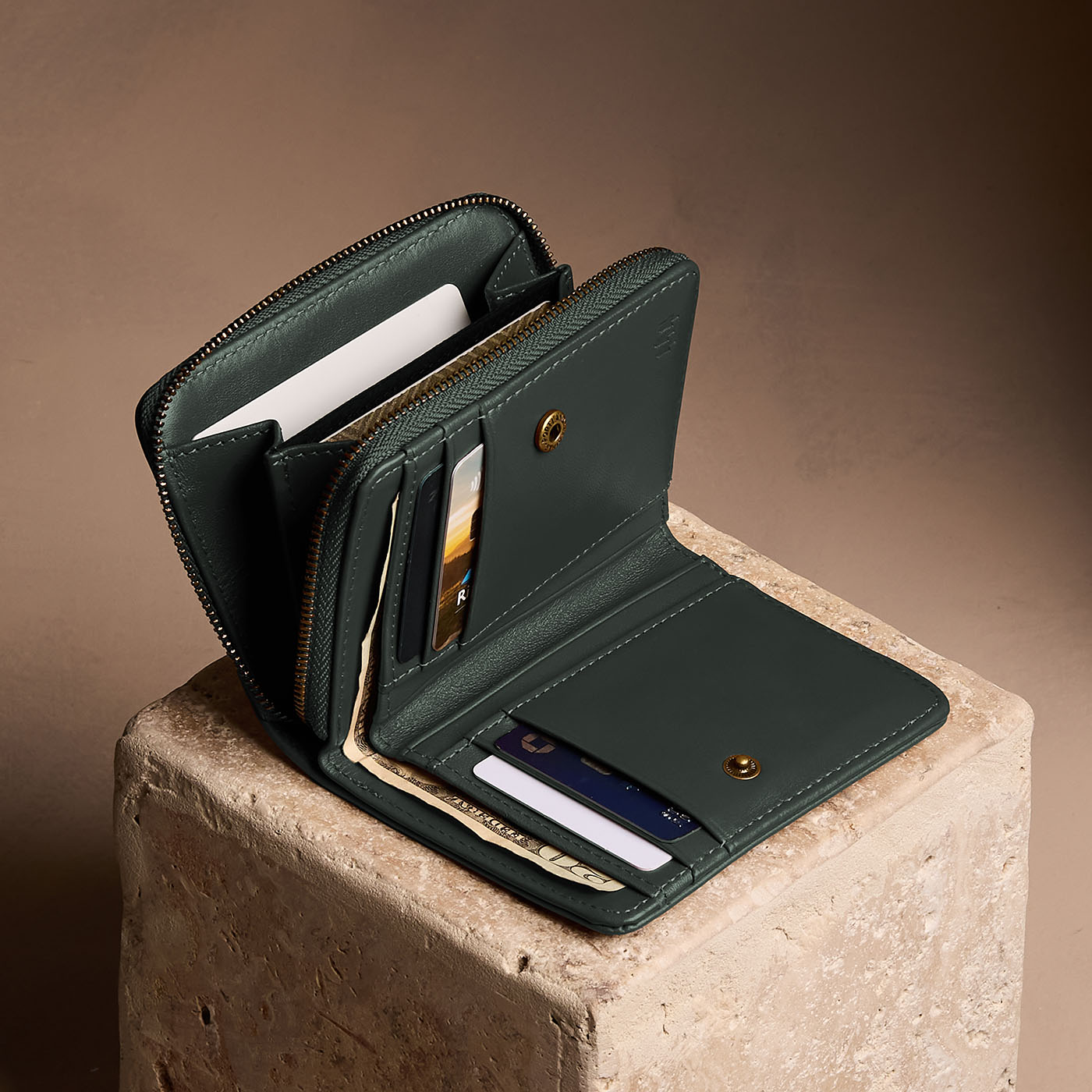 Regent Green | Open wallet with card and storage pockets on a light brown background