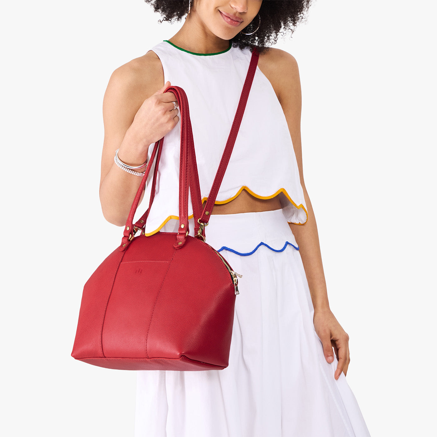 Cherry*Large | Model holding a half circle crossbody bag with handles and removable crossbody strap