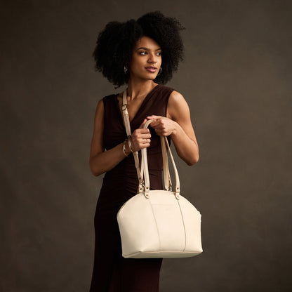 Pebbled Bone*Large | Model holding a half circle crossbody bag with handles and removable crossbody strap