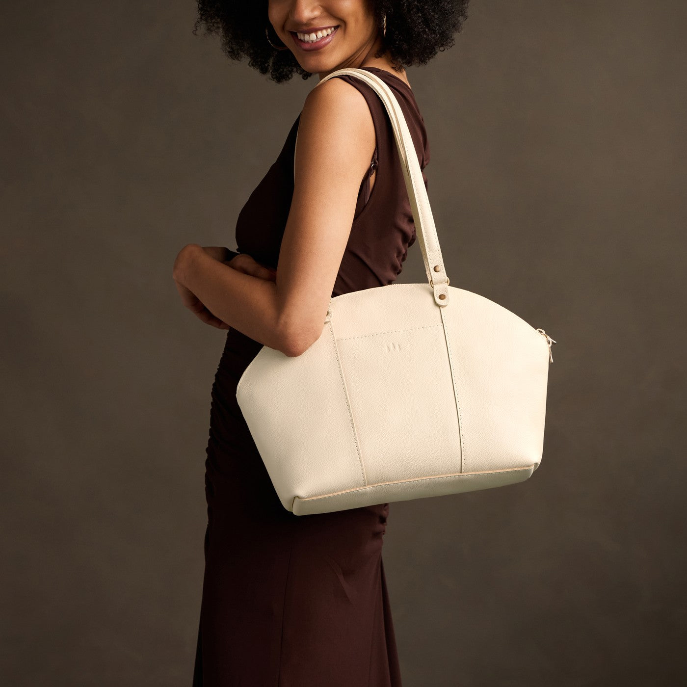 Pebbled Bone*Large | Model holding a half circle crossbody bag with handles and removable crossbody strap