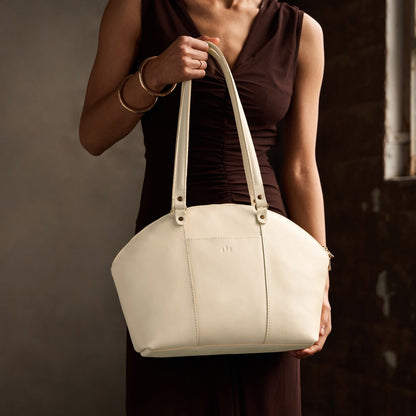 Pebbled Bone*Large | Model holding a half circle crossbody bag with handles and removable crossbody strap