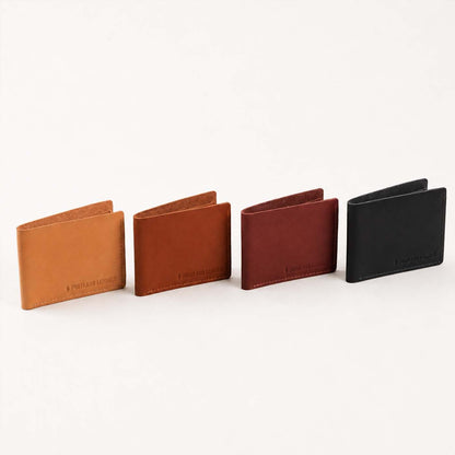 Toscano | Four leather bifold wallets lined up in a row on a clean white background. Each wallet features a minimalist bi-fold design with a debossed logo near the bottom edge.