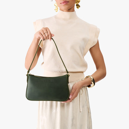 Evergreen*Small | Model carrying petite bean shaped shoulder bag with a zipper closure